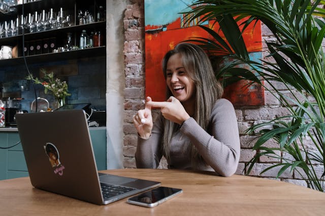 Photo, woman using ASL on a video meeting