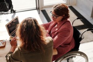 Photo, a woman in a wheelchair consulting with an advocate
