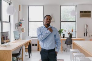 Photo, man standing in ASL classroom making hug gesture with one hand