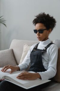 Photo, woman sitting and reading Braille book